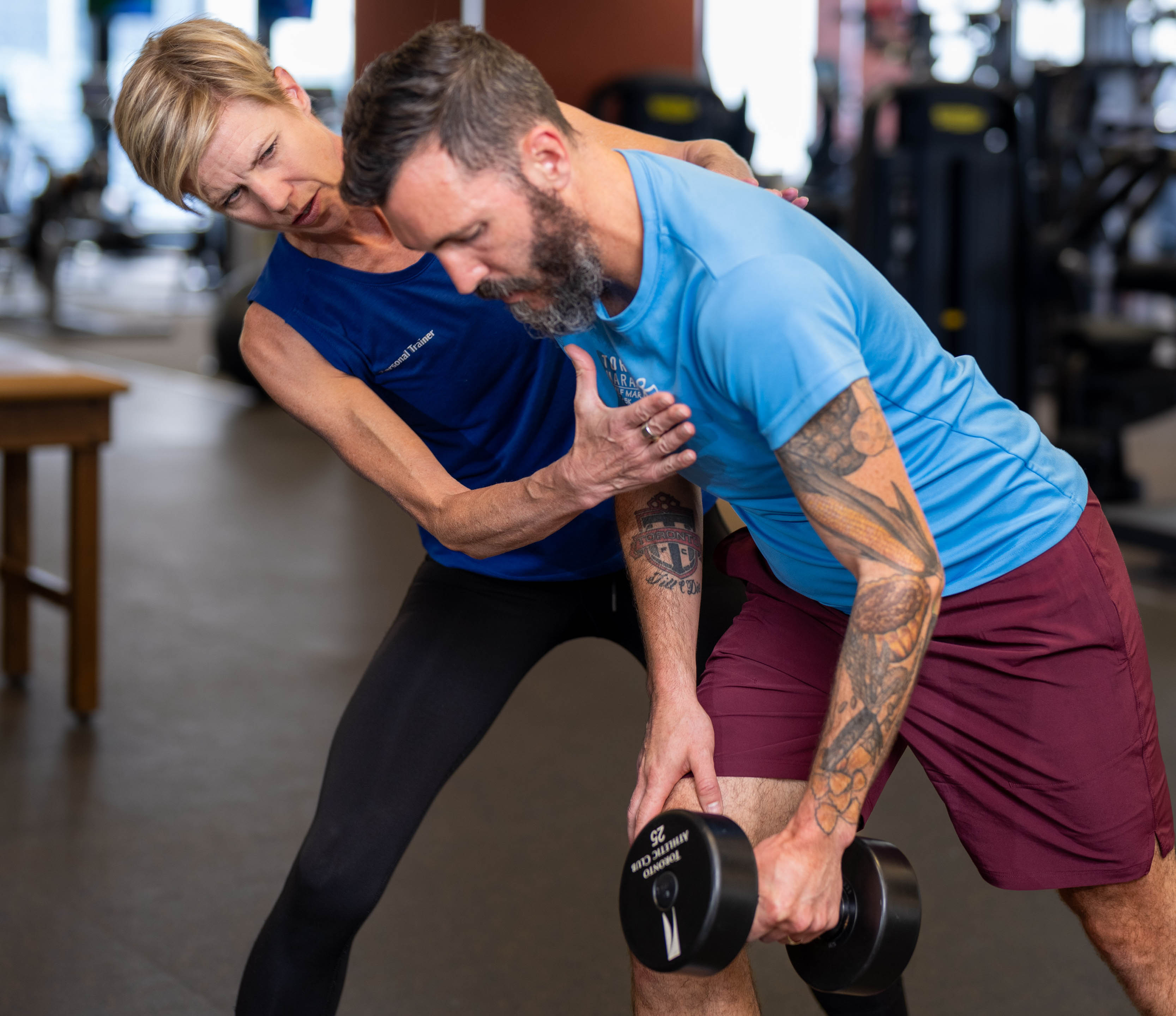 Female trainer from the Toronto Athletic Club (Meg Sharp) training with her male client on the gym floor Female trainer from the Toronto Athletic Club (Meg Sharp) training with her male client on the gym floor